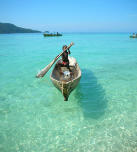enfant dans un canoë sur une mer turquoise translucide